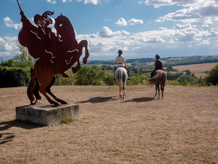 Deux cavalières admirent le paysage à Lupiac avec la signalétique de la Route de d'Artagnan